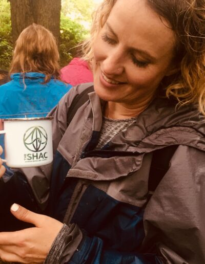 woman outdoors holding SHAC mug