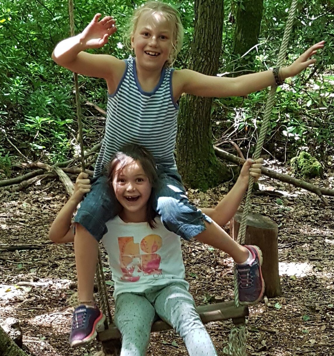 children playing on a swing in the woods with the SHAC